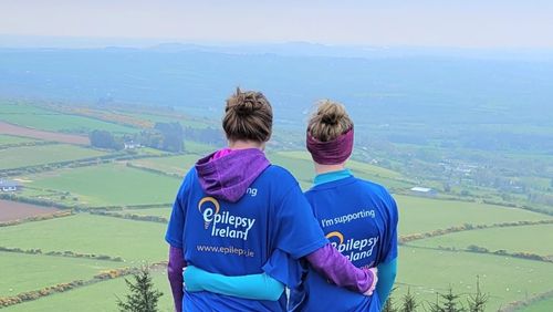 Two EI Volunteers on top of hill looking over scenery
