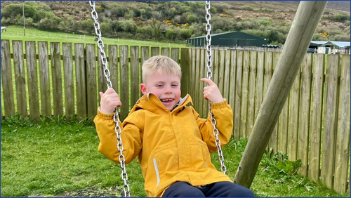 Cole playing on a swing 
