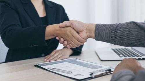 two people shaking hands at job interview.