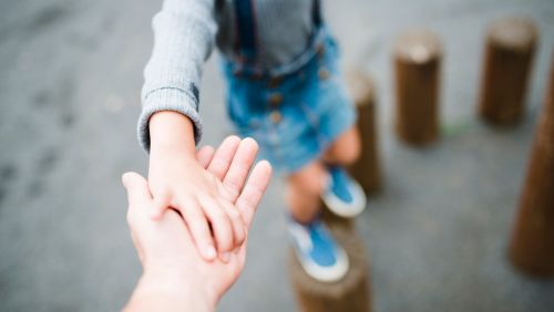 Parent holding child's hand