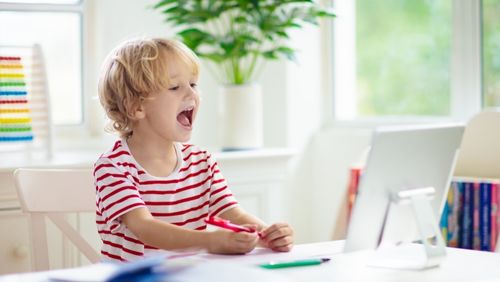 Child looking at computer and laughing