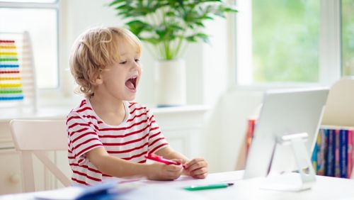 Child looking at computer and laughing