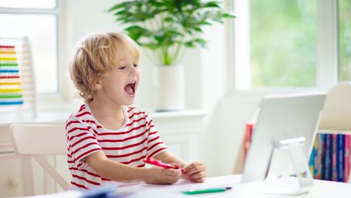 Child looking at computer and laughing