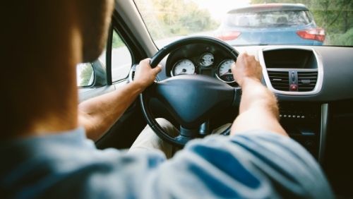 man behind a wheel of a car.