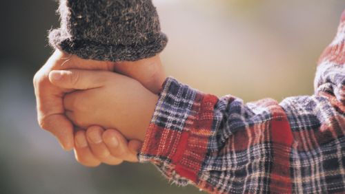 Father holding child's hand.