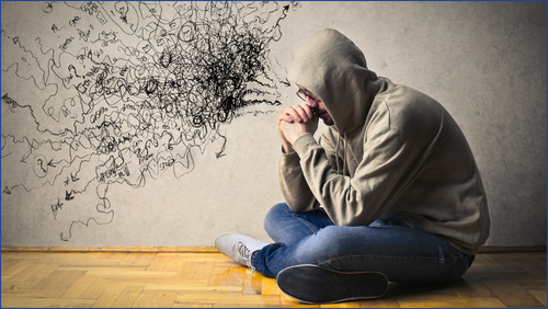 Man sitting on floor with text coming out of his head depicting restless thoughts