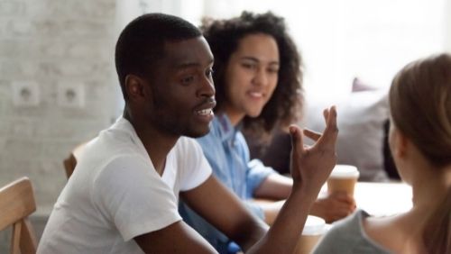 a man talking to group of friends.