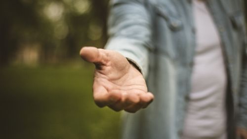 a person reaching out their hand to help.