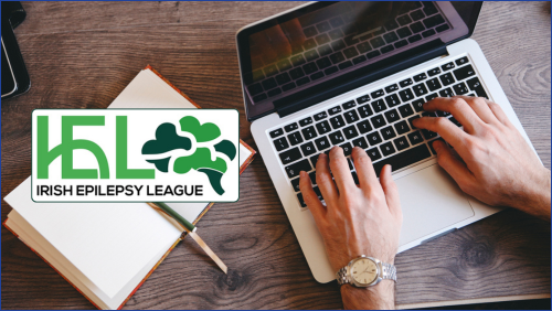 Person typing and a notebook with Irish Epilepsy League Logo to the LHS