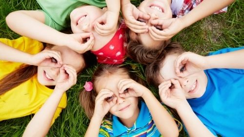 group of children lying on the ground smiling