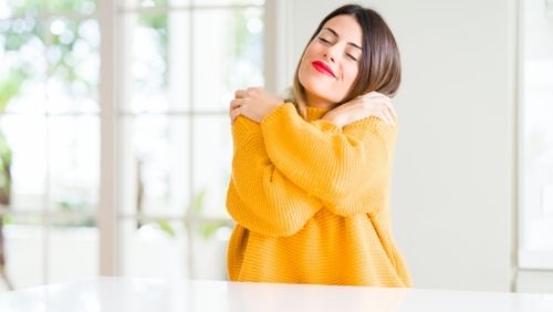 woman hugging herself.