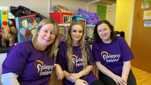 Three supporters celebrating Purple Day, wearing EI Purple T-shirts