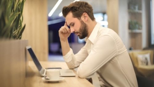 man trying to concentrate while looking at a laptop.