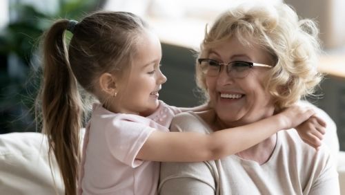 grandmother being hugged by her granddaughter.