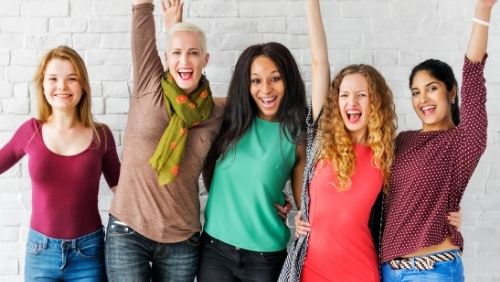 group of women smiling and embracing.