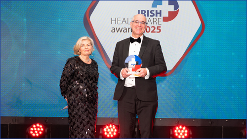 Woman in a black dress and man in a black suit standing in a stage