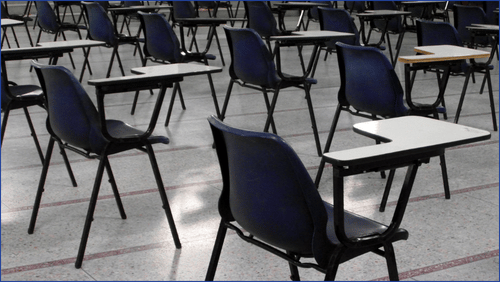 Exam hall with desks and chairs in it