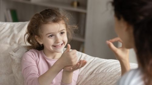 a child giving thumbs up to adult.