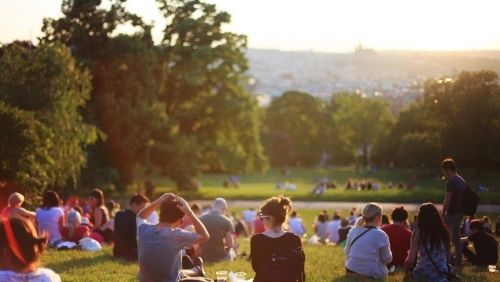 Group of people watching the sun in a park.