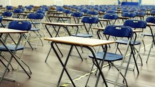 an empty exam hall with desks and chairs.