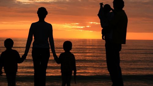 Family on beach at sunset