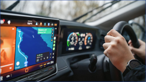 Hands driving a steering wheel with sat nav