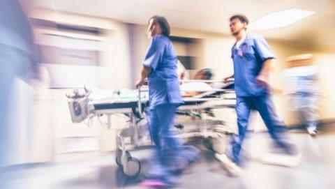 Two hospital staff pushing a trolley