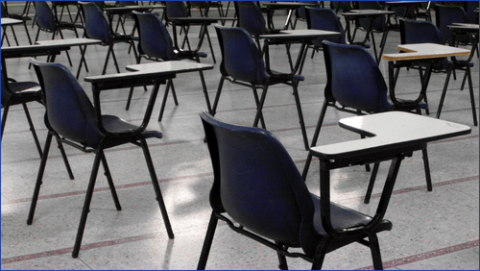 Exam hall with desks and chairs in it