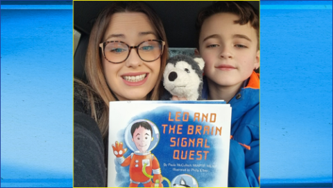 Paula and Leo holding a copy of the new book